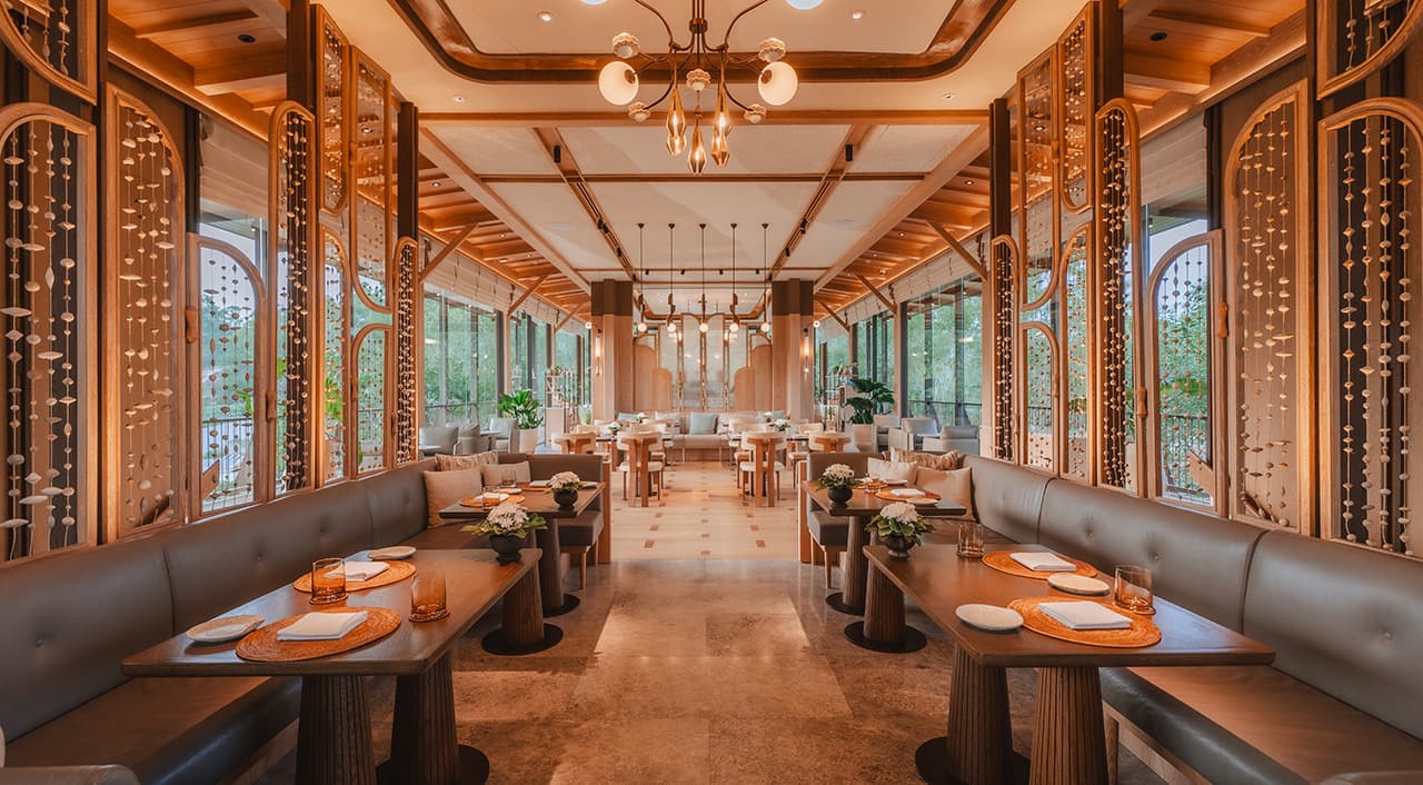 JAMPA restaurant interior at Tri Vananda Phuket with wood-panelled dining room and ornate hanging bead curtains