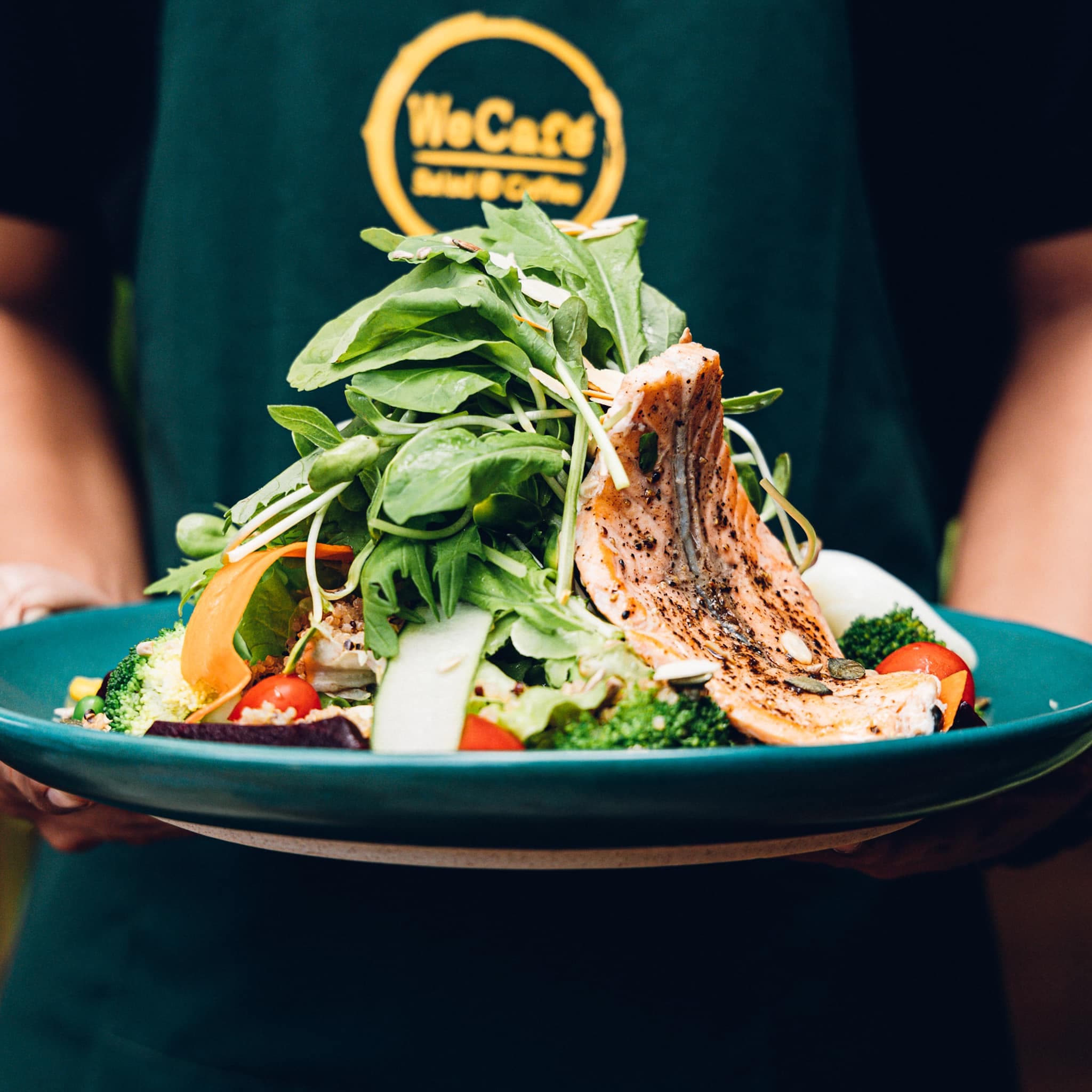 WeCafe salmon salad bowl with fresh greens broccoli and cherry tomatoes
