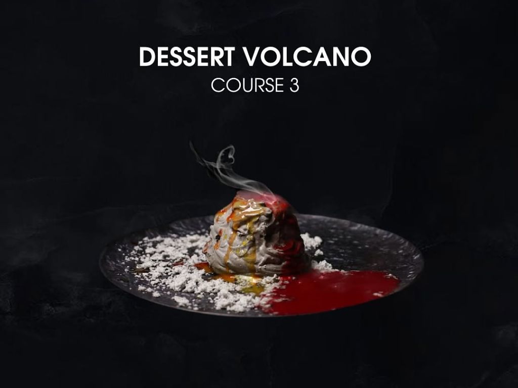 Smoky Volcano Dessert served as course three at Dinner In The Sky Phuket, presented on a black plate with dramatic flair.