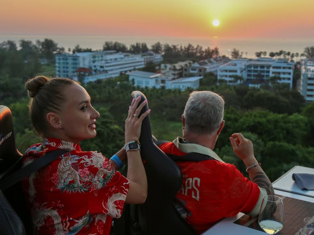Couple enjoying a sunset view while dining at Dinner In The Sky Phuket above Kata and Karon.