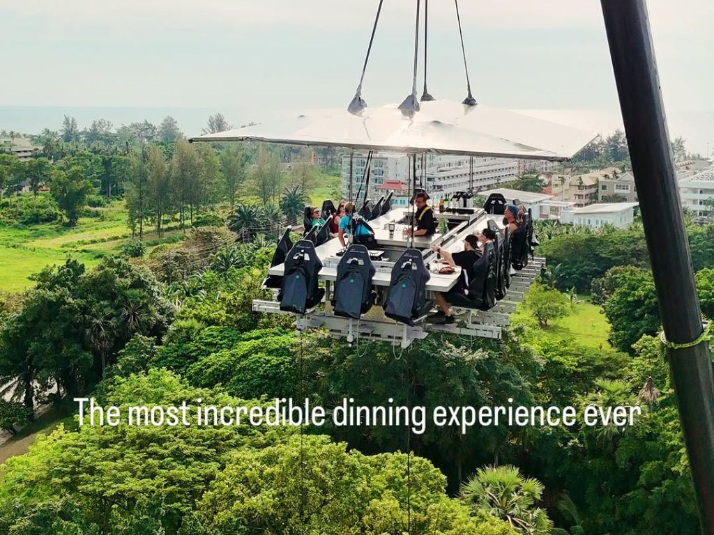 Guests suspended mid-air at Dinner In The Sky Phuket enjoying a unique restaurant experience above Kata and Karon.