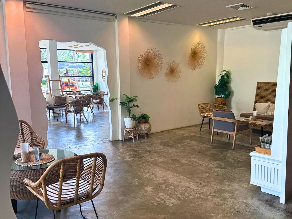 Minimalist and airy interior of Café Studio in Kata Karon featuring natural decor, woven chairs, and soft lighting.