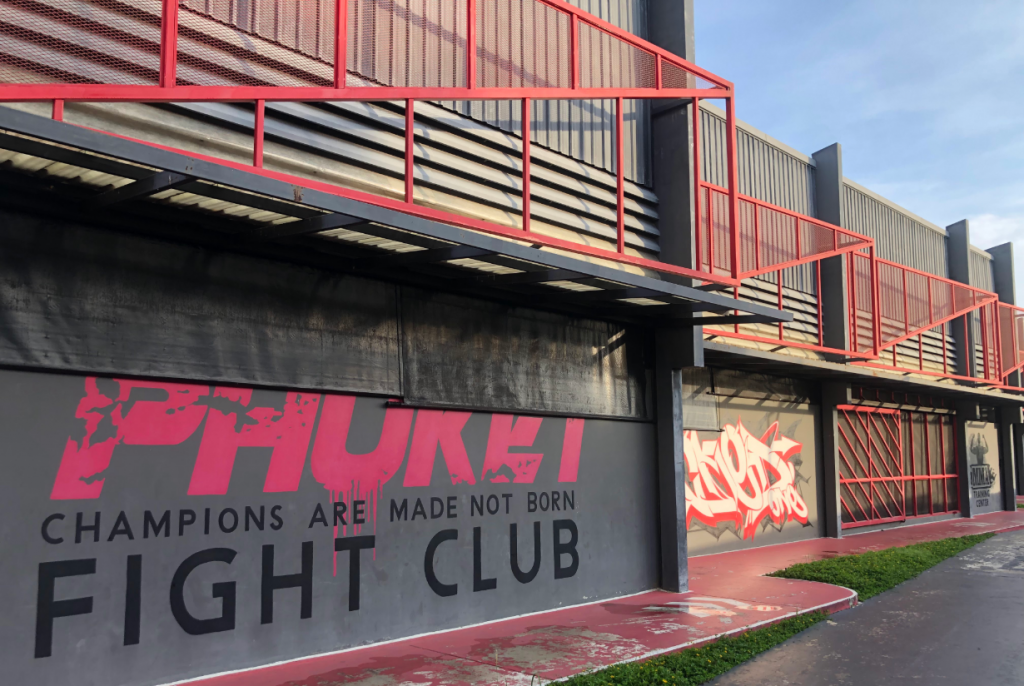 Exterior wall of Phuket Fight Club gym in Phuket with red accents and motivational quote