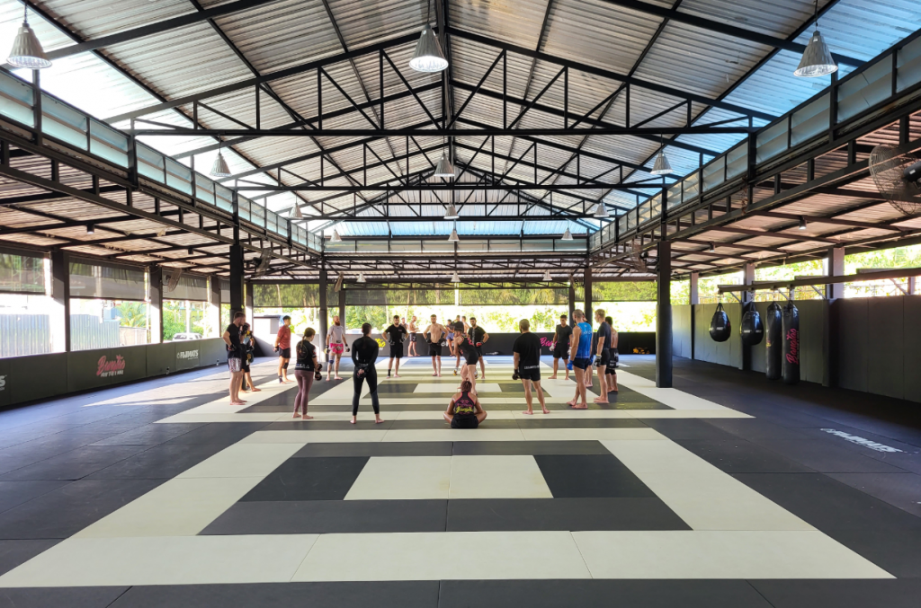 Muay Thai class at Bangtao Muay Thai gym in Phuket with students training on large mat space